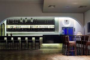Innenansicht der Prova Wein Bar im Albatros Spa & Resort mit Barhockern und einer gut bestückten Bar.