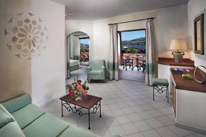 Innenansicht der Suite im Resort Cala Di Falco mit Blick auf den Balkon und das Meer.