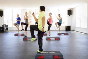 Fitnesskurs im Robinson Djerba Bahiya Hotel mit Teilnehmern auf Stepper-Plattformen.