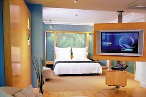 Ein Hotelzimmer im Cumberland mit einem Bett, Fernseher, und einem Tisch