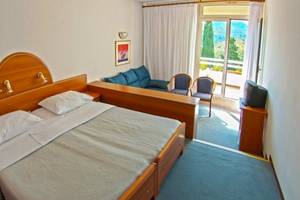 Hotelzimmer im Osmine Slano mit zwei Betten, einem Fernseher und einem Balkon.