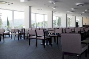 Innenansicht des Restaurants im Osmine Slano Hotel mit runden Tischen und Stühlen.