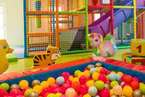 Kinderspielplatz im Hotel Osmine Slano mit vielen bunten Bällen, bunten Spielsachen und einem großen Spielturm.