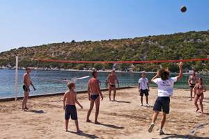 Mehrere Personen spielen Volleyball auf einem Strand in der Nähe des Osmine Slano Hotels.
