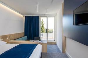 Hotelzimmer im Osmine Slano mit Bett, Schreibtisch, Fernseher und Balkon.