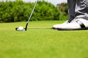 Golfer bereitet sich darauf vor, den Ball auf dem Golfplatz zu putten.