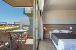Akti Palace Hotel Zimmer mit Balkon und Meerblick, modernes Interieur, helle Farben, bequemes Bett und Tisch mit Stühlen