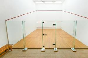 Innenansicht des Squash-Courts im Iberostar Grand El Mirador Hotel mit Glaswänden und hölzernem Boden.
