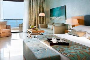 Hotelzimmer im Ikos Oceania mit Blick auf das Meer, Möbel und Dekor.