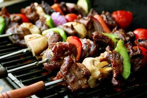 Gegrillte Fleisch- und Gemüsespieße auf einem Grillrost