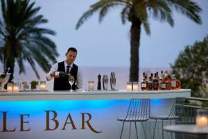 Barkeeper des Rhodes Bay Hotel & Spa serviert ein Getränk an der Bar.