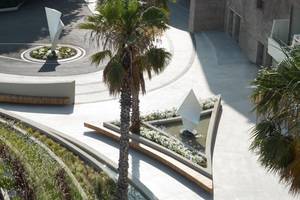Aussenbereich des Rhodes Bay Hotel & Spa mit Palme, Brunnen und Garten