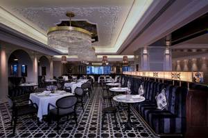 Innenansicht des Restaurants im Conrad Abu Dhabi Etihad Towers mit edlem Interieur, Kristallleuchtern und eleganten Möbeln.
