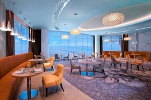 Innenraum des Conrad Abu Dhabi Etihad Towers Hotel mit modernen Möbeln und großen Fenstern.