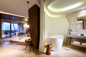 Innendesign eines Zimmers im TRS Coral Hotel mit Badewanne, Bett und Badezimmerspiegel.