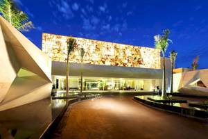 Außenansicht des TRS Coral Hotels bei Nacht mit beleuchteter Fassade und Wasserfeature