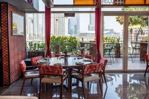 Innenbereich des Hotels Taj Dubai mit einem runden Esstisch und Blick auf die Stadt