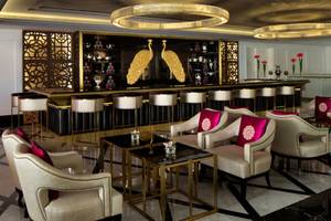 Die Lobby-Bar im Taj Dubai Hotel mit goldenen Pfauen und eleganten Möbeln.