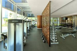 Fitnesscenter im Taj Dubai Hotel mit modernen Geräten und großem Fenster.