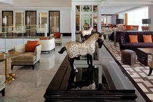 Innenansicht der Lobby des Taj Dubai Hotels mit Möbeln und einer Pferdestatue.