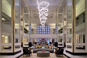 Foyer des Taj Dubai Hotels mit Kristallleuchte und Blumenarrangement.