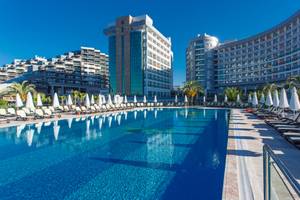 Außenpool des Sherwood Exclusive Lara Hotels mit Sonnenliegen und Palmen