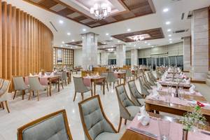 Innenansicht des Restaurants im Sherwood Exclusive Lara Hotel mit gedeckten Tischen und Stühlen.