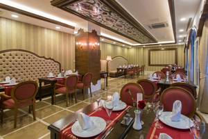 Restaurantbereich des Sherwood Exclusive Lara Hotels mit gedeckten Tischen und Stühlen.
