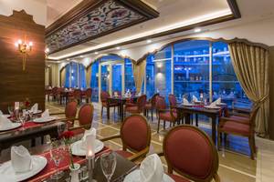 Innenbereich des Sherwood Exclusive Lara Hotel Restaurants mit gedeckten Tischen und Stühlen.