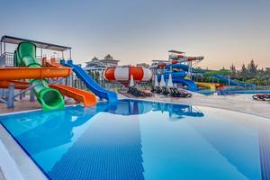 Wasserpark des Sherwood Exclusive Lara Hotels mit mehreren Wasserrutschen und Sonnenliegen.