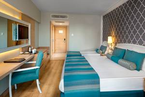 Doppelzimmer im Sherwood Exclusive Lara Hotel mit zwei Betten, Schreibtisch und Fernseher.