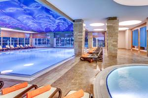 Innenbereich des Sherwood Exclusive Lara Pools mit blauer Decke und Loungestühlen