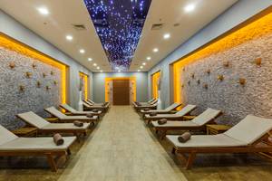 Relaxationsraum im Sherwood Exclusive Lara Hotel mit gepolsterten Liegen und Steinwänden.