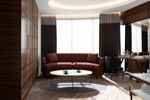 Innenraum des Sherwood Exclusive Lara Hotels mit rotem Sofa, Tisch und braunen Vorhängen.