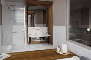 Badezimmer im Sherwood Exclusive Lara Hotel mit weißen Marmorwänden, einer Dusche und einem Waschtisch.