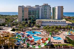 Luftaufnahme des Sherwood Exclusive Lara Hotels mit Wasserrutschen und Poolanlage am Meer