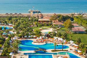 Luftaufnahme des Sherwood Exclusive Lara Resorts mit Swimmingpools, Sonnenliegen und Hotels am Meer.
