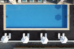 Obersicht des Pools im Boutique 5 Hotel & Spa mit weißen Sonnenschirmen und Liegestühlen.