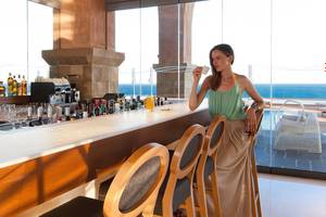 Frau an der Bar des Boutique 5 Hotel & Spa mit Blick auf das Meer