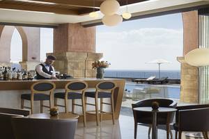 Barbereich des Boutique 5 Hotel & Spa mit Blick auf das Meer und Liegestühlen.