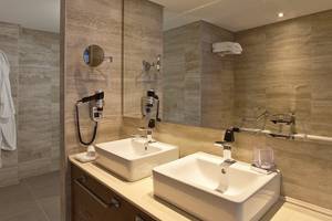 Badezimmer im Boutique 5 Hotel & Spa mit zwei Waschbecken, Spiegeln und Handtüchern.