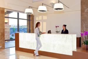 Empfangsbereich im Boutique 5 Hotel & Spa mit einer Rezeptionistin und einer Frau, die an der Rezeption steht.
