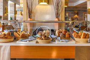 Frühstücksbuffet im Creta Star Hotel mit verschiedenen Brotsorten in Körben.