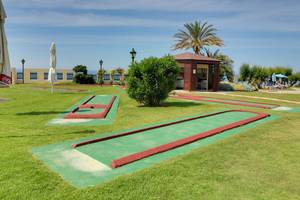 Minigolf-Anlage im Freien neben dem Creta Star Hotel mit blauem Himmel und Palmen.