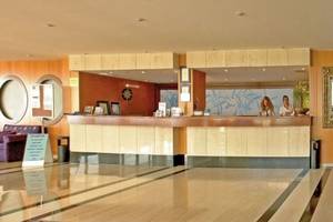 Empfangsbereich des Royal & Imperial Belvedere Hotels mit zwei Mitarbeitern hinter der Rezeptionstheke.