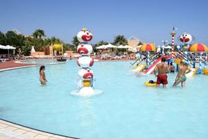 Menschen spielen im Poolbereich des Royal & Imperial Belvedere Hotels, umgeben von bunten Wasserspielgeräten.