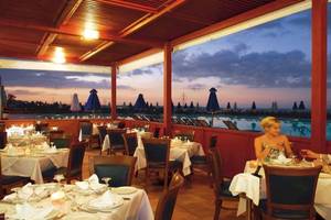 Paar sitzt in einem Restaurant des Royal & Imperial Belvedere Hotels und genießt ein Abendessen mit Blick auf den Pool.