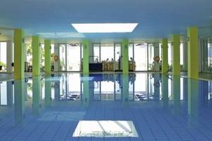 Innenpool des Royal & Imperial Belvedere Hotels mit blauen Fliesen und gelben Säulen.