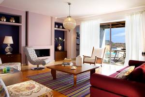 Wohnzimmer im Domes of Elounda, Autograph Collection mit gepolsterten Stühlen und einem Tisch.