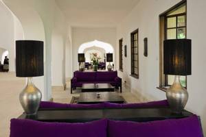 Loungebereich des Swahili Beach Resorts mit lila Sofas, schwarzen Tischen und silbernen Lampen.